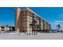 Beachside condo building with a pool, lounge chairs and palm trees in a beautiful tropical setting at 1255 Tarpon Center Dr # 604, Venice, FL 34285