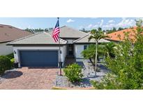 Charming single-story home featuring a manicured lawn, paver driveway, and neutral paint scheme at 1481 Hyssop Loop, North Port, FL 34289