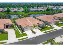Charming attached villa with two-car garage, lush landscaping, and serene water views at 1493 Maseno Dr, Venice, FL 34292