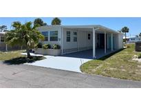Charming single-story home with a covered carport, palm trees, and well-maintained landscaping at 202 Mantua Dr, Venice, FL 34285
