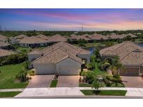 Beautiful lakefront home featuring a tile roof and well-manicured landscaping at 21649 Avon Park Ct, Venice, FL 34293