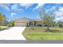 Single story home featuring an attached garage, well-kept lawn, and mature landscaping at 2618 Titania Rd, Englewood, FL 34224