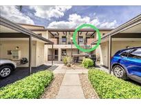 Condo with covered parking, well-maintained landscaping, and private entry stairs to the second floor at 410 Mission E Trl # B, Venice, FL 34285