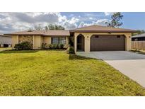 Charming single-story home with stone accents, well-manicured lawn, and a two-car garage at 4270 Ascot Dr, North Port, FL 34291