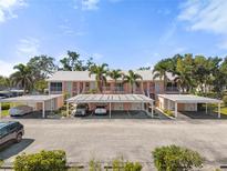 Charming two-story building features covered parking, lush palm trees, and a well-maintained landscape at 458 Cerromar Rd # 382, Venice, FL 34293