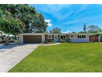 Charming single-story home featuring a manicured lawn, brick driveway, and a quaint front garden at 4616 Leeta Ln, Sarasota, FL 34234
