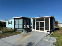 Charming blue home featuring a screened-in porch and a welcoming front entrance at 56 Lakeview Dr, North Port, FL 34287