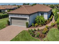 Well-maintained home with a two-car garage, beautiful landscaping, and a brick driveway at 5853 Semolino St, Nokomis, FL 34275