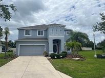 Charming two-story home with a well-manicured lawn and a two-car garage showcasing beautiful curb appeal at 5966 Willows Bridge Loop, Ellenton, FL 34222