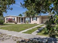 Charming single-story home with a well-maintained lawn, flowering bushes, and a welcoming entrance at 6231 Jordan St, North Port, FL 34287