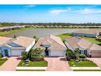 Stunning aerial view of the beautiful community, highlighting the lake and manicured landscaping at 629 Ibiza Loop, Venice, FL 34292