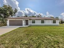 Charming single-story home with a lush front lawn, a two-car garage, and a welcoming entrance at 6497 Honeycomb Cir, North Port, FL 34291