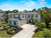 Stunning two-story home featuring a gray tile roof, two-car garage, and meticulously landscaped front yard at 678 Clear Creek Dr, Osprey, FL 34229