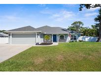Charming single-story home with a well-manicured lawn, blue door, and inviting curb appeal at 755 Mohawk Rd, Venice, FL 34293