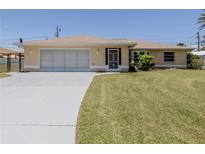 Charming home with a well-manicured lawn and a driveway leading to a two-car garage at 976 Euclid Rd, Venice, FL 34293