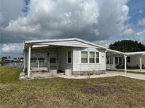 Charming single-story home featuring a covered entrance and a well-maintained front yard at 103 Lakeview Dr, North Port, FL 34287
