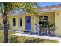 Charming home with a vibrant blue front door and well-manicured landscaping at 10444 Willmington Blvd, Englewood, FL 34224
