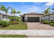 Charming single-story home with lush landscaping, palm trees and a brick driveway at 13486 Nobilio St, Venice, FL 34293