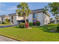 Well-maintained condo building with lush landscaping and covered parking on a sunny day at 1728 S Lakeside Ct # 1720B, Venice, FL 34293