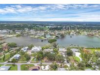 Panoramic aerial view of waterfront homes and community with lush landscaping, and a beautiful blue sky at 205 Louella Ln, Nokomis, FL 34275