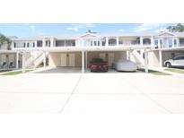 Condominium exterior showcasing covered parking, stairs leading to the 2nd floor, and a well-maintained facade at 320 Clearbrook Cir # 203, Venice, FL 34292