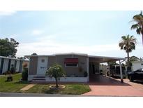 Charming single-story home with a carport, well-maintained lawn, and mature landscaping at 373 Longwood Dr, Venice, FL 34285