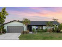 Charming single-story home featuring a lush front yard, well-maintained landscaping, and a two-car garage at 5140 Administration St, Port Charlotte, FL 33948