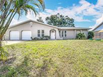 Charming single-story home featuring a spacious front yard and a two-car garage at 7140 Teaberry St, Englewood, FL 34224