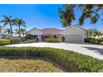 Charming single-story home boasts a well-manicured lawn and lush landscaping at 838 Carnoustie Dr, Venice, FL 34293