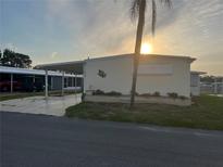 Charming manufactured home featuring a covered carport and well-maintained landscaping at 868 Baveno Dr, Venice, FL 34285