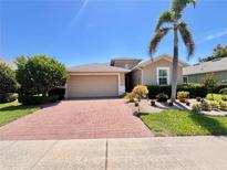 Charming home featuring a brick driveway, meticulously manicured landscaping, and a two-car garage at 9118 Coachman Dr, Venice, FL 34293