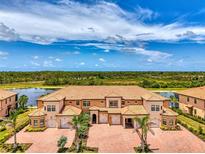 Beautiful townhouse with a red brick driveway, three garage spaces, and scenic views at 10213 Staggerbush Dr # 202, Venice, FL 34293