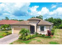 Charming single-story home featuring a tile roof and meticulously manicured landscaping at 12871 Cinqueterre Dr, Venice, FL 34293