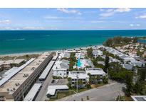 Breathtaking aerial view of beachside condos with white roofs, set against a turquoise ocean backdrop at 1555 Tarpon Center Dr # G 235, Venice, FL 34285