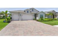 Charming single-Gathering home featuring a brick driveway, a two-car garage, and a well-manicured lawn with mature landscaping at 15963 Crofton Springs Way, Port Charlotte, FL 33953