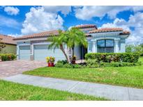 Charming single-story home featuring a three-car garage, well-manicured lawn, and lush tropical landscaping at 20235 Granlago Dr, Venice, FL 34293