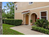 Inviting townhouse exterior featuring a well-maintained front yard and charming front door at 3613 Parkridge Cir # 11-201, Sarasota, FL 34243