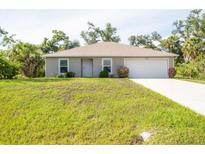 Well-maintained single-story home featuring a two-car garage, fresh landscaping, and a bright, inviting facade at 4890 Laramie Cir, North Port, FL 34286