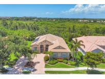 Aerial view of single-Gathering home with lush greenery shows curb appeal and surrounding landscape at 5018 Bella Terra Dr, Venice, FL 34293