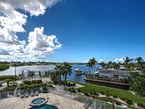 Stunning waterfront views featuring boat docks, lush landscaping and a blue sky at 516 Tamiami S Trl # 303, Nokomis, FL 34275