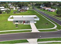 Charming single Gathering home featuring a well-manicured lawn and a pristine white fence surrounding the property at 7505 Wexford St, North Port, FL 34287
