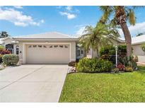 Charming single-story home with a two-car garage, lush landscaping, and well-manicured lawn at 1110 Southlake Ct, Venice, FL 34285