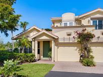 Charming two-story home with a green front door, lush landscaping, and a paver driveway leading to the garage at 1164 Beachcomber Ct # 19, Osprey, FL 34229