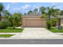 Charming single-story home with a well-manicured lawn, palm trees and a two-car garage at 11954 Tempest Harbor Loop, Venice, FL 34292