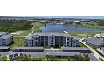 Beautiful aerial view of the condo community with a pond, golf course, and covered parking at 12140 Wellen Golf St # 202, Venice, FL 34293
