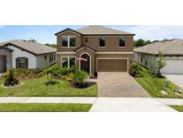 Beautiful two-story home featuring a manicured lawn, brick-paved driveway, and attached two-car garage at 12617 Oak Hill Way, Parrish, FL 34219