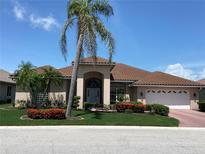 Charming single-story home featuring a tile roof, well-manicured lawn, and lush landscaping at 1345 Reserve Dr, Venice, FL 34285