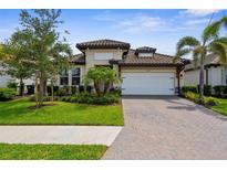 Charming single-story home with lush landscaping and a brick-paved driveway at 19927 Bridgetown Loop, Venice, FL 34293