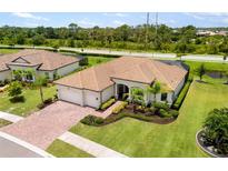 Stunning home with a tile roof, well-manicured lawn, and a three car garage at 20443 Cristoforo Pl, Venice, FL 34293