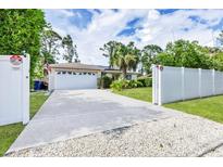 Charming single-story home with a well-manicured lawn and a concrete driveway leading to a two-car garage at 2445 Apache St, Sarasota, FL 34231